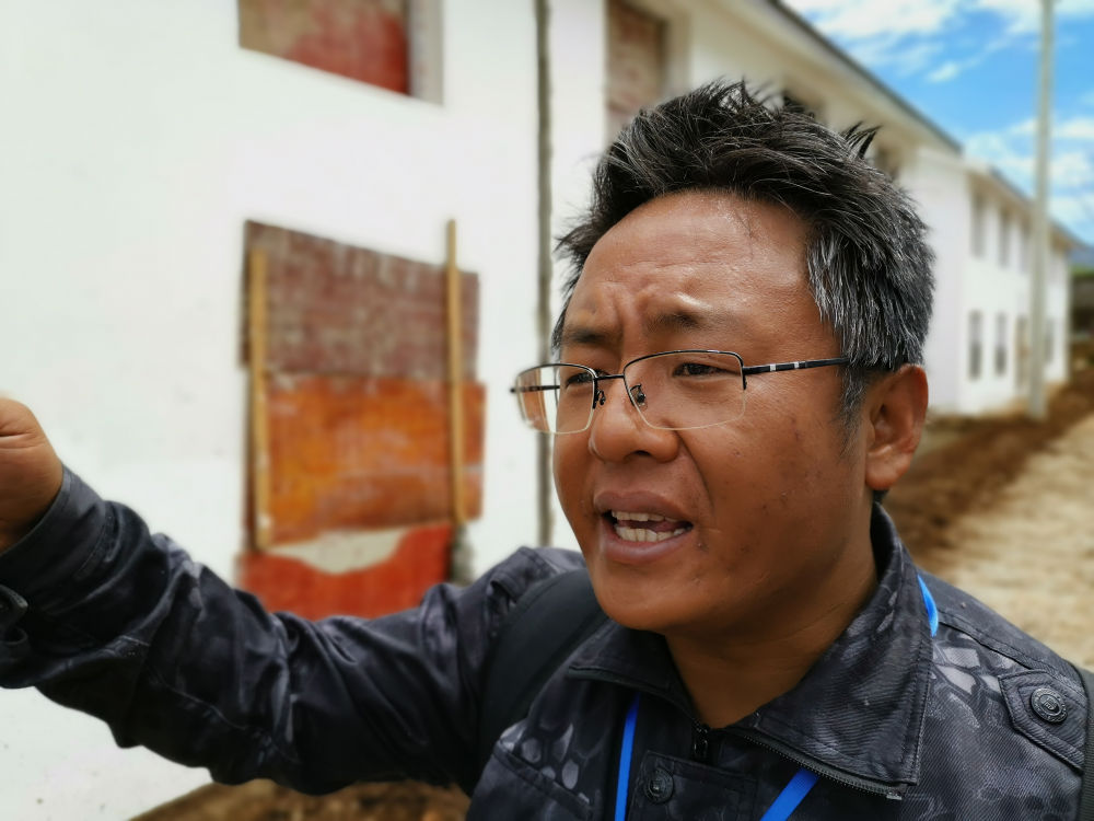 　　四川省布拖县乐安乡党委副书记木乃什古在查看建设中的洛恩村安全住房路面质量（5月23日摄）。新华社记者 谢佼 摄